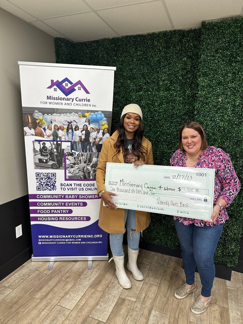 Karen Lowerr of Remedy Consulting presenting check to Jessica Currie of Missionary Currie 4 Women and Children in Milwaukee, WI in December 2023.