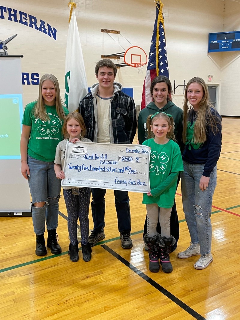 Lowerr Family of Remedy Consulting presenting check to Fund for 4-H Education in Waukesha, WI in 2021.  Members of Washington 4-H Club (Big Bend, WI) held the check in this photo.