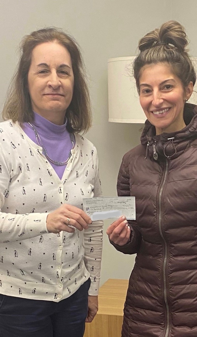Bank of New England's AVP Business Development Officer, Thea Tsagaris (right), presenting the check to Ellen Bedrosian (left), Manager of Stewardship, of The Lazarus House in Lawrence, MA.